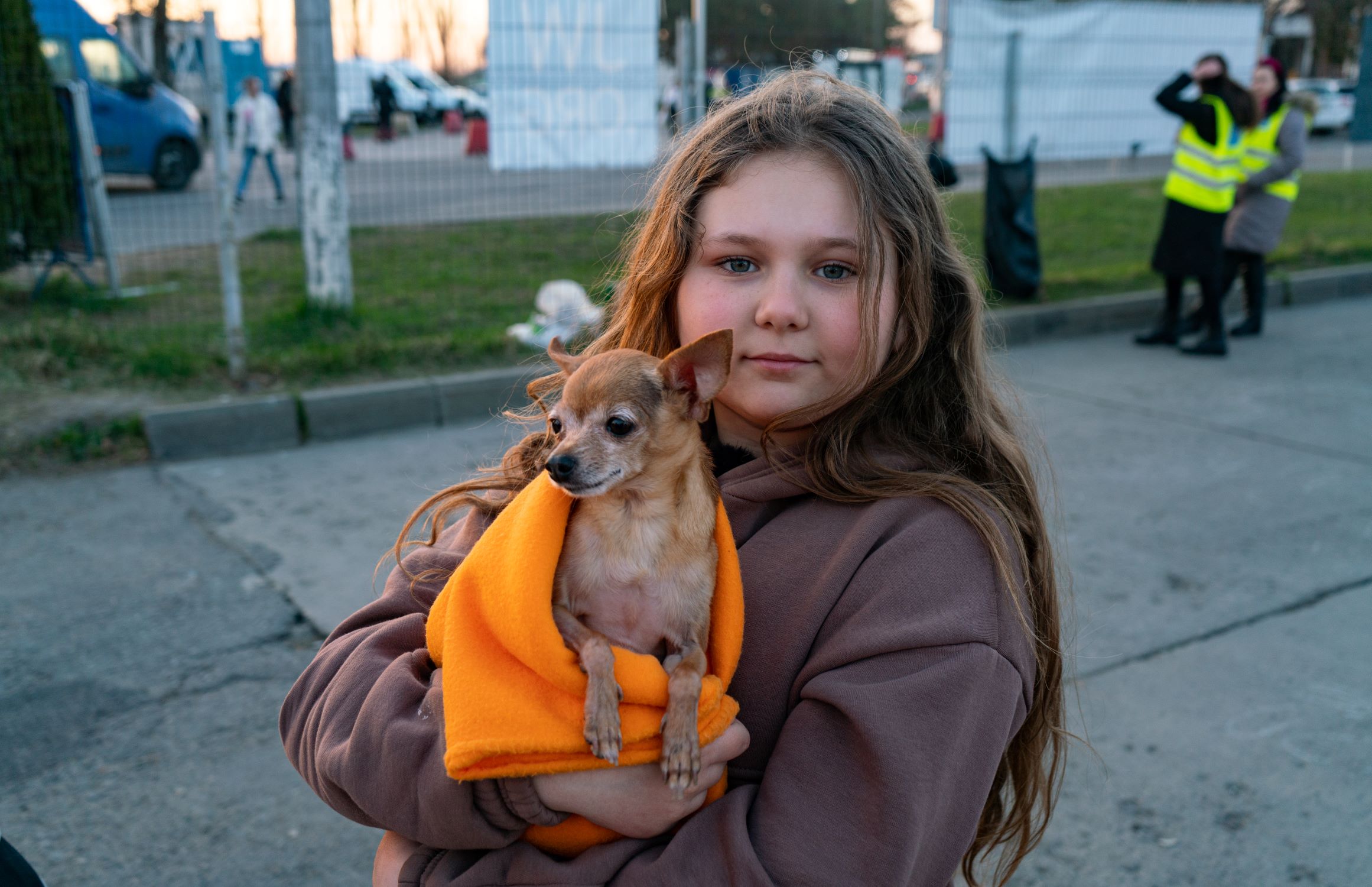 Young Ukrainian refugee is holding her small dog