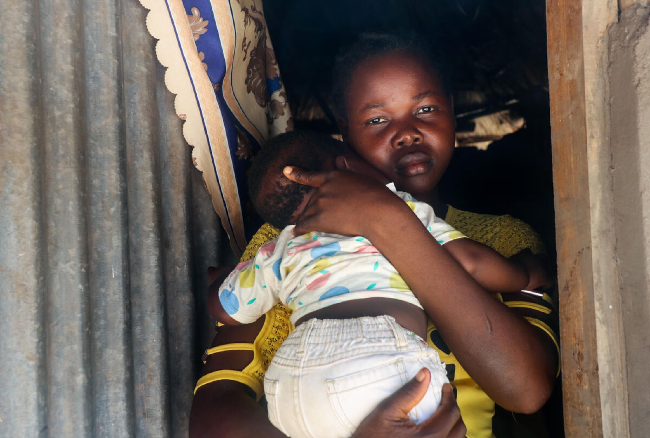 A South Sudanese girl holds her child