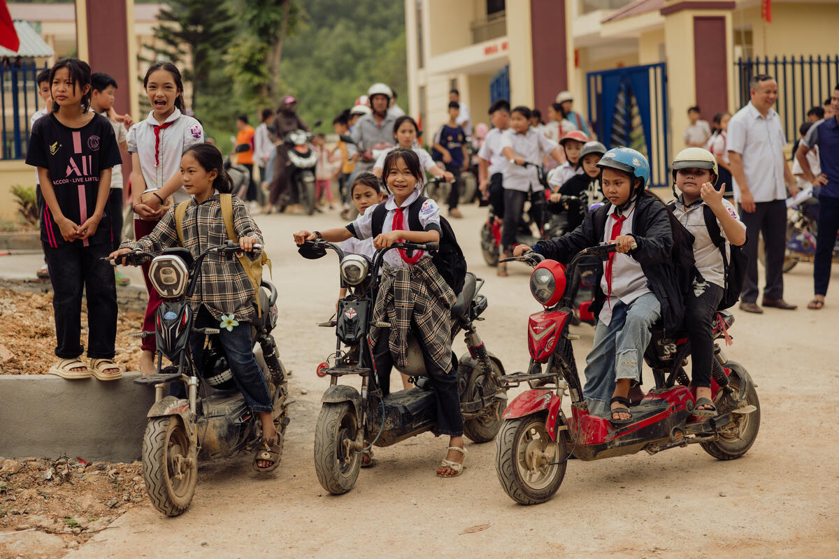 A group of children from a play group ride their scooters
