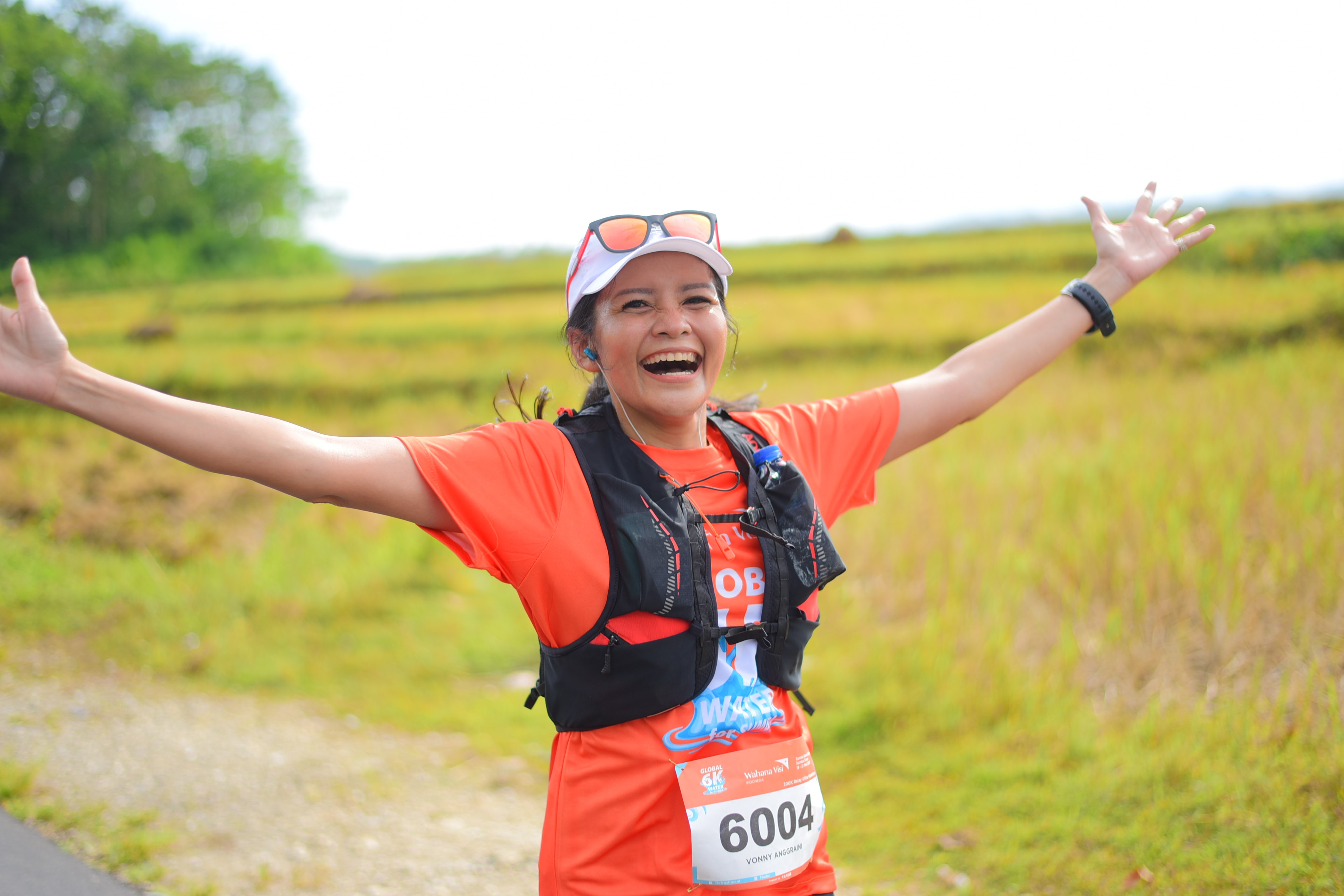 Three participants running while wearing orange t-shirts at at a Global 6K event