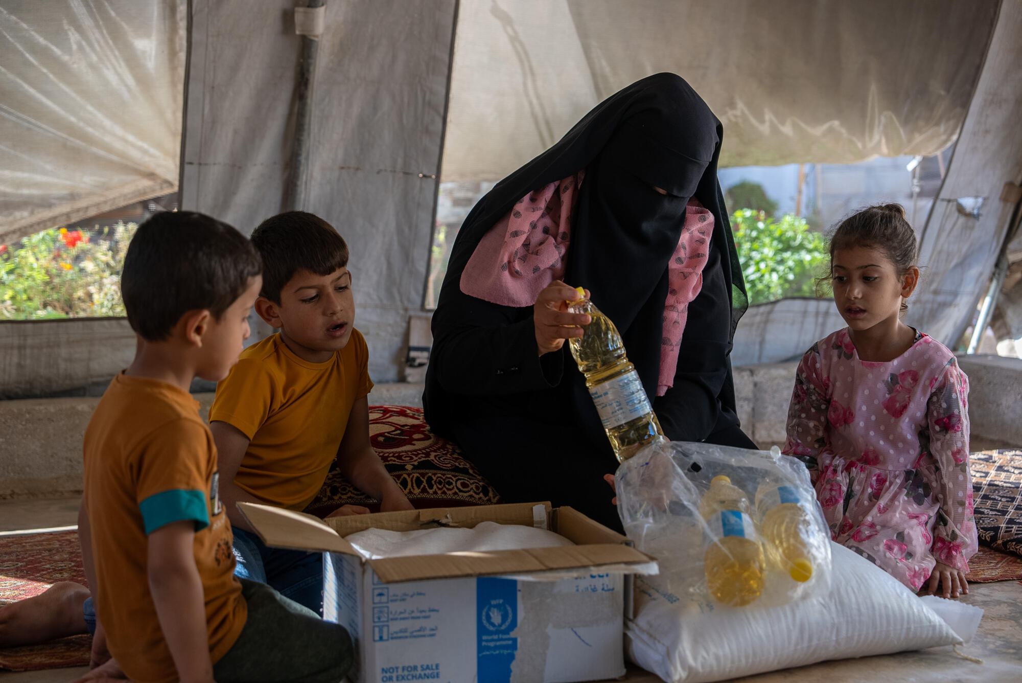A mother and children opening an aid parcel