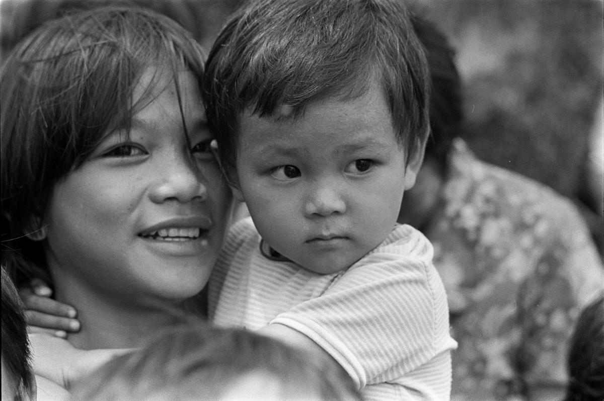Two refugees on the Seasweep, the smaller child clings to the older child.