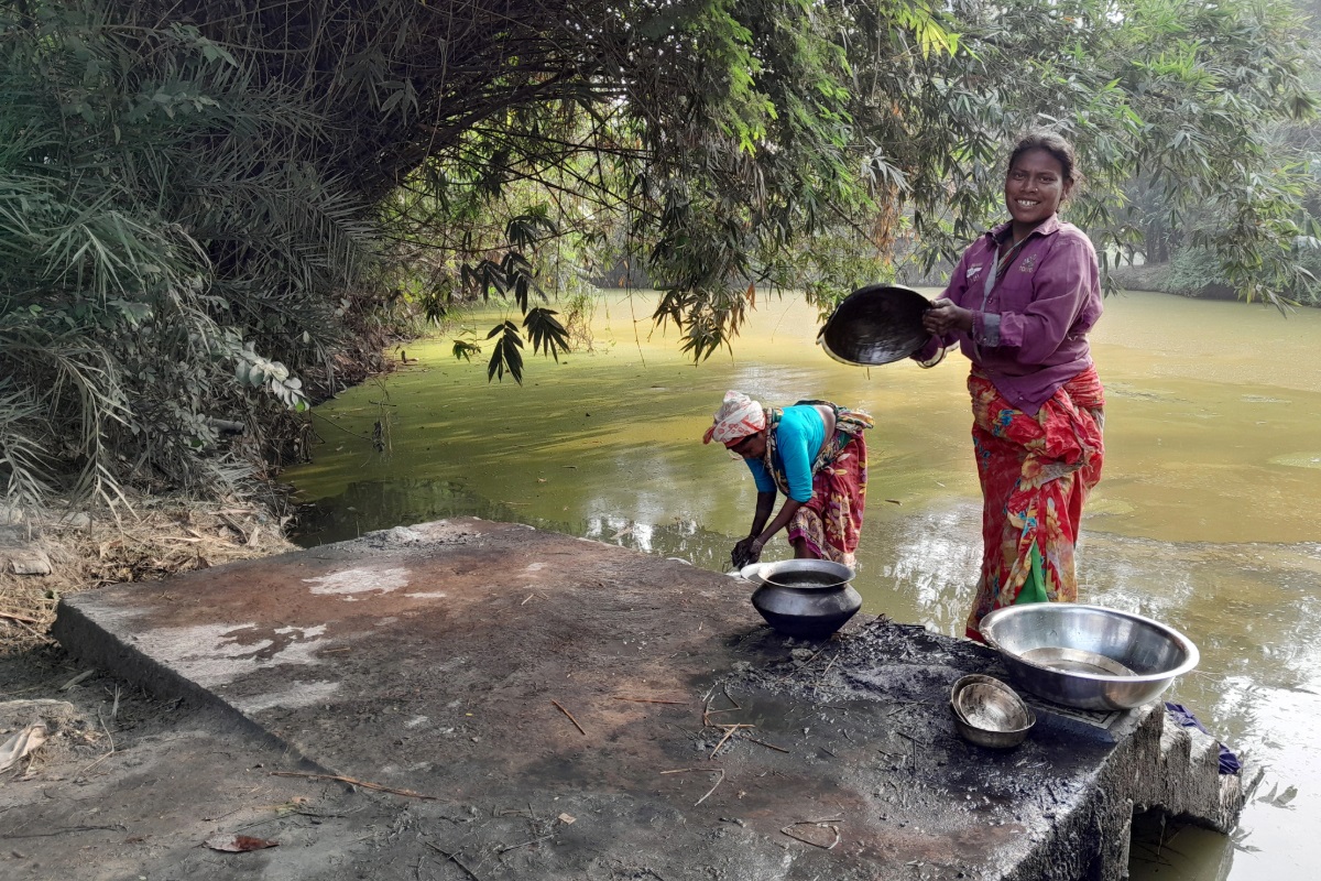 Women collect water from a lake in Ghoraghat