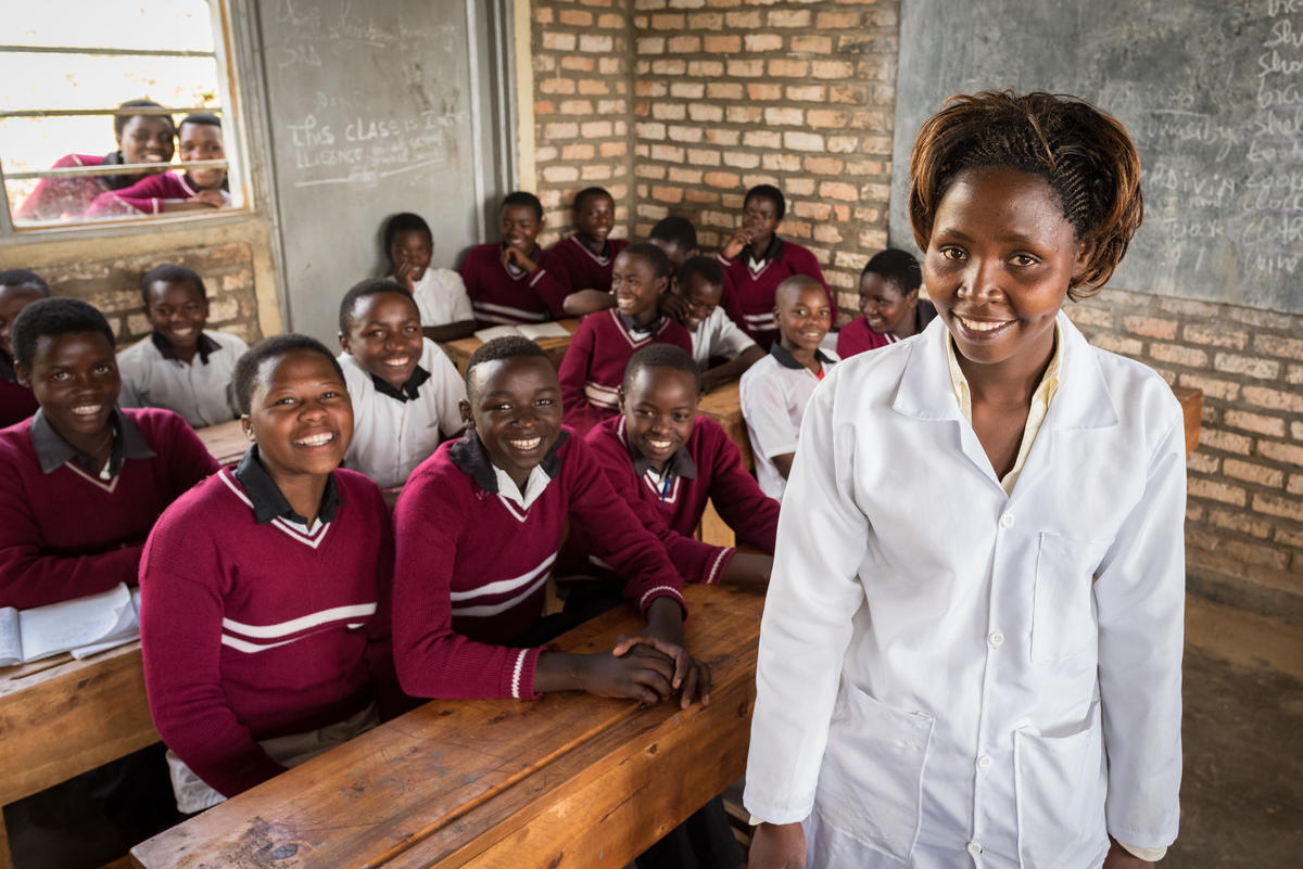 Marline stands with her classroom of children, all smiling