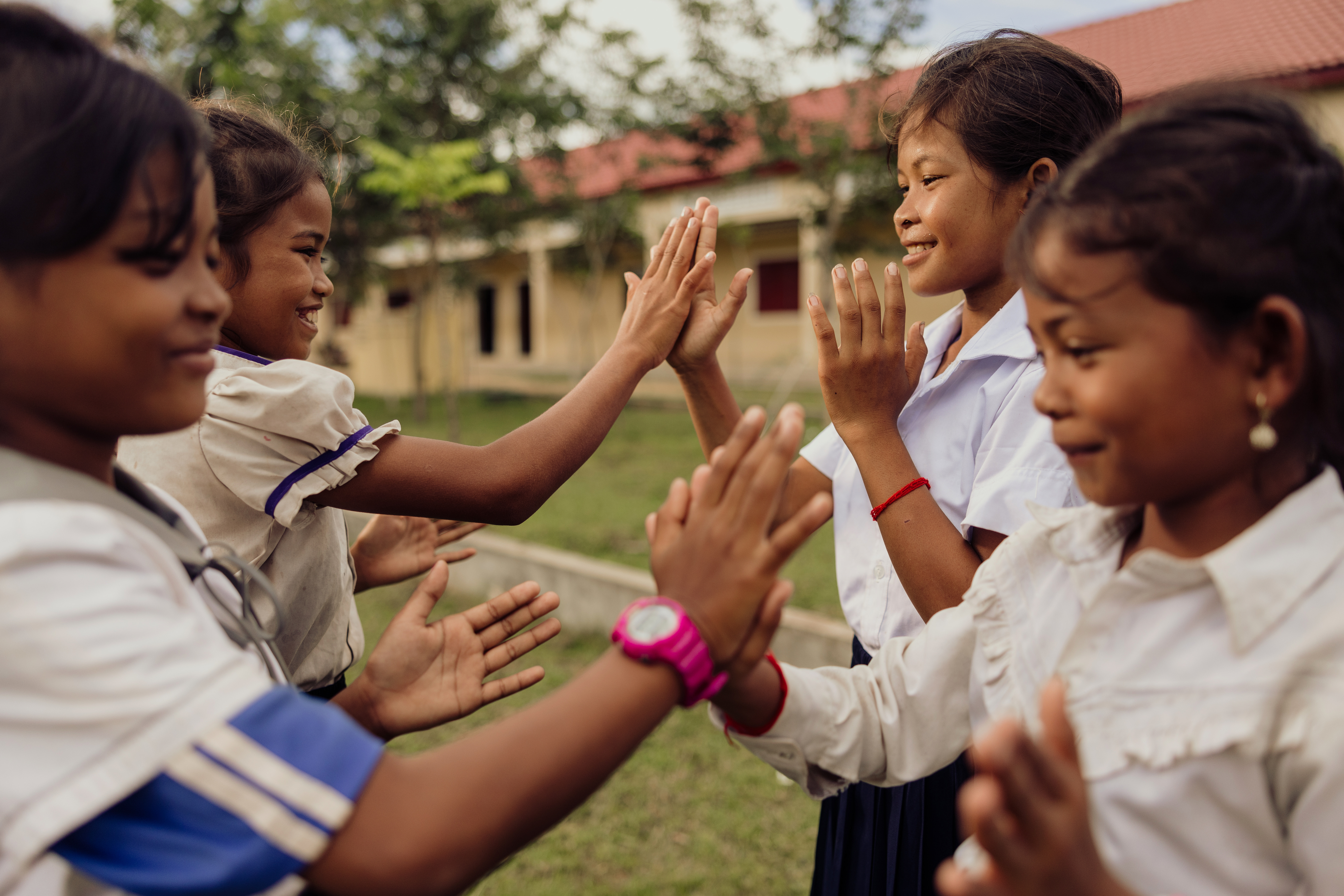 A group of four young girls enjoying hand clapping games in Cambodia