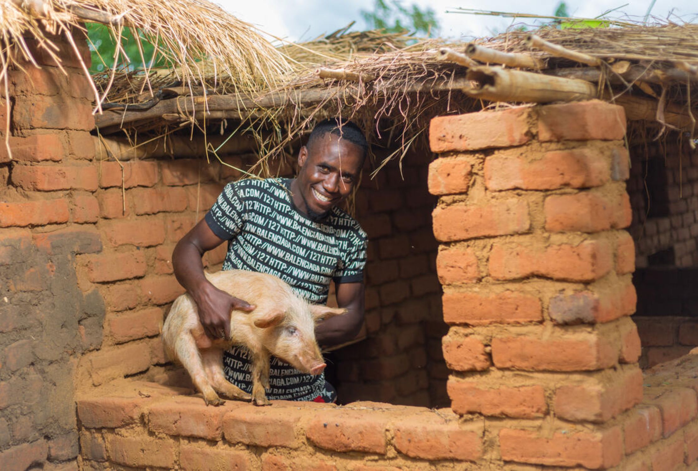 Boy holding a pig and smiling at the camera