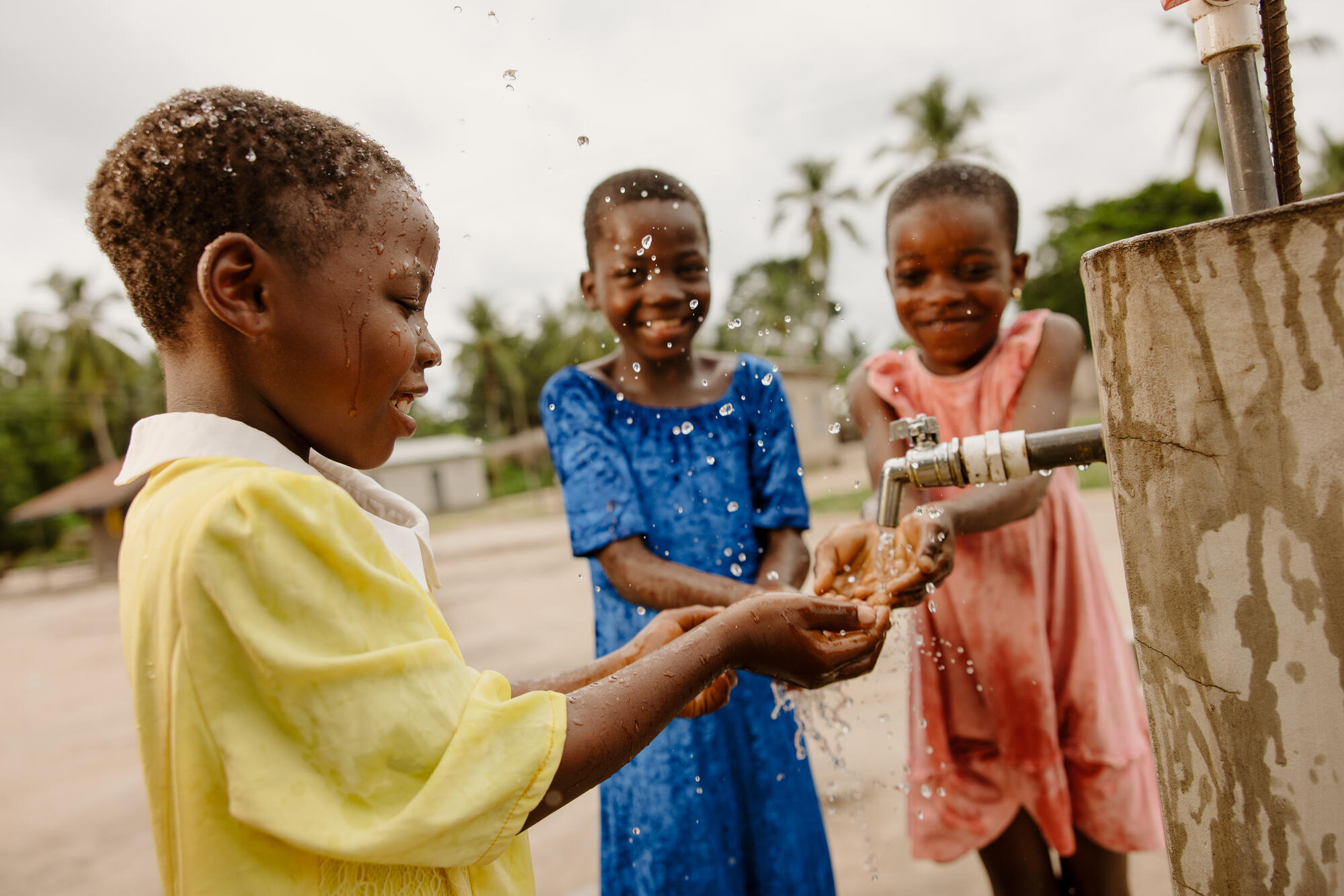 A young girl in Ghana enjoying clean drinking water