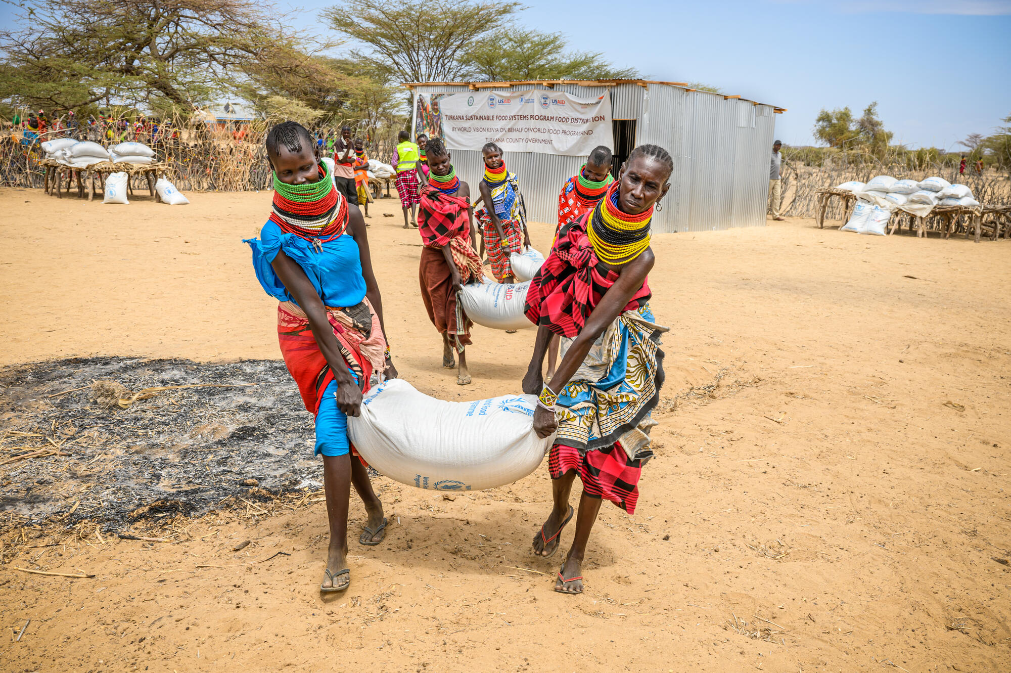 People in Kenya carry bags of food supplies