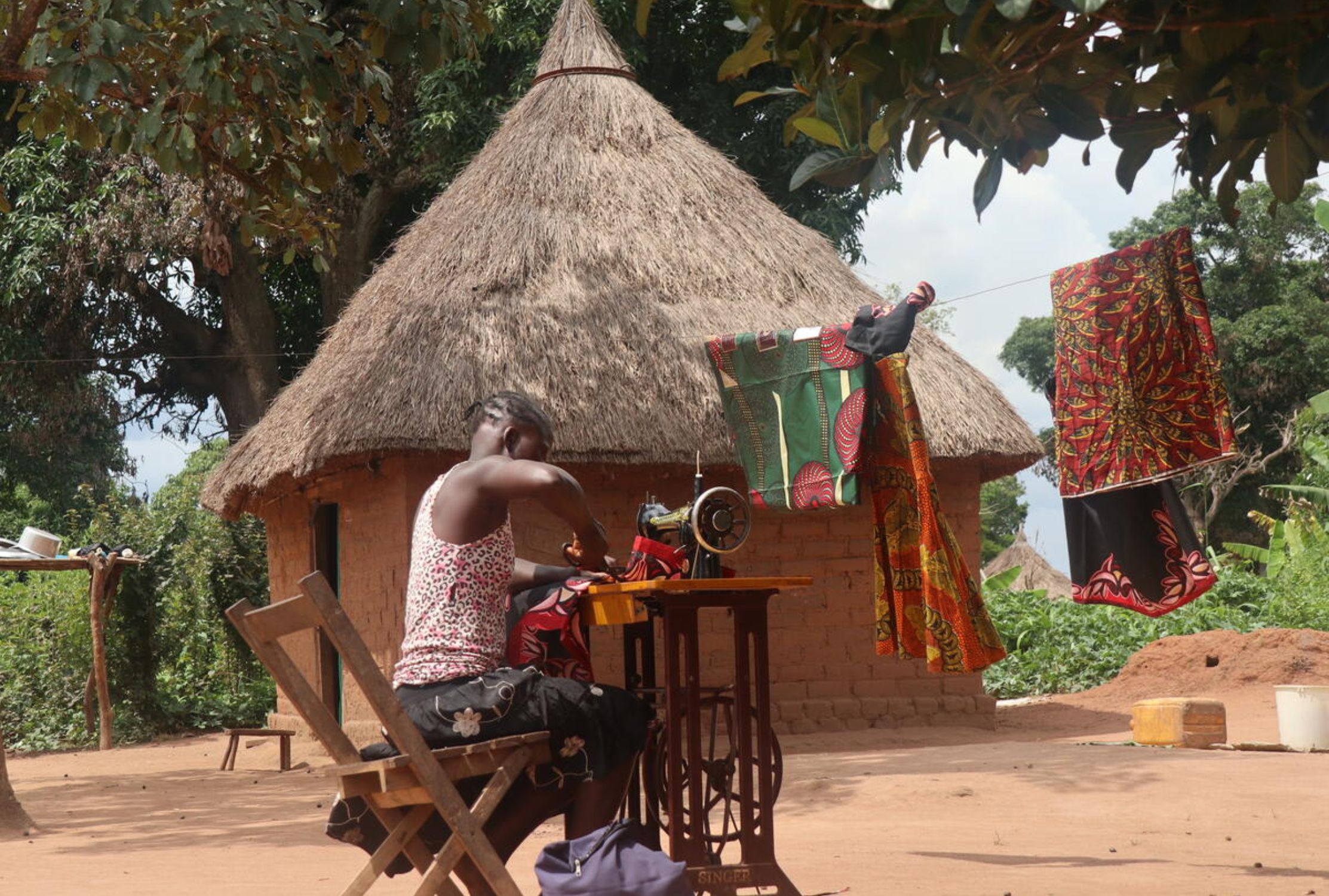 South Sudanese girl using a sewing machine to generate an income for her family