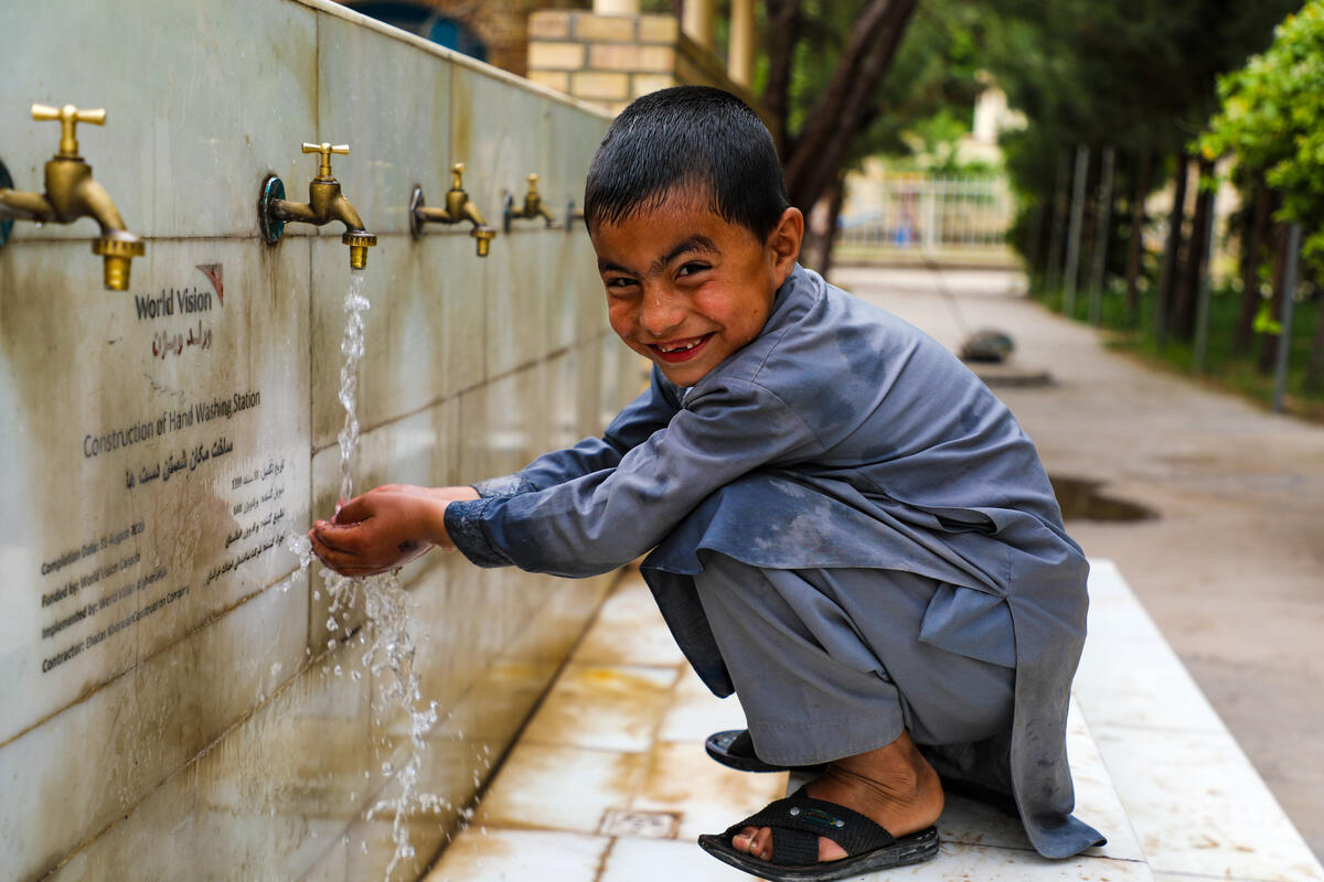 A young boy washed his hands at a World Vision donated water collection point