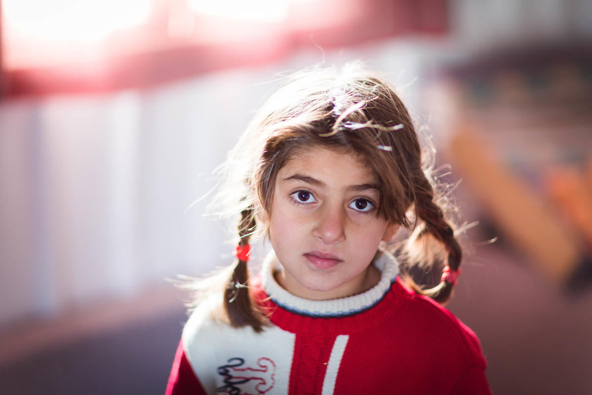 Young Syrian girl stares at camera in refugee camp
