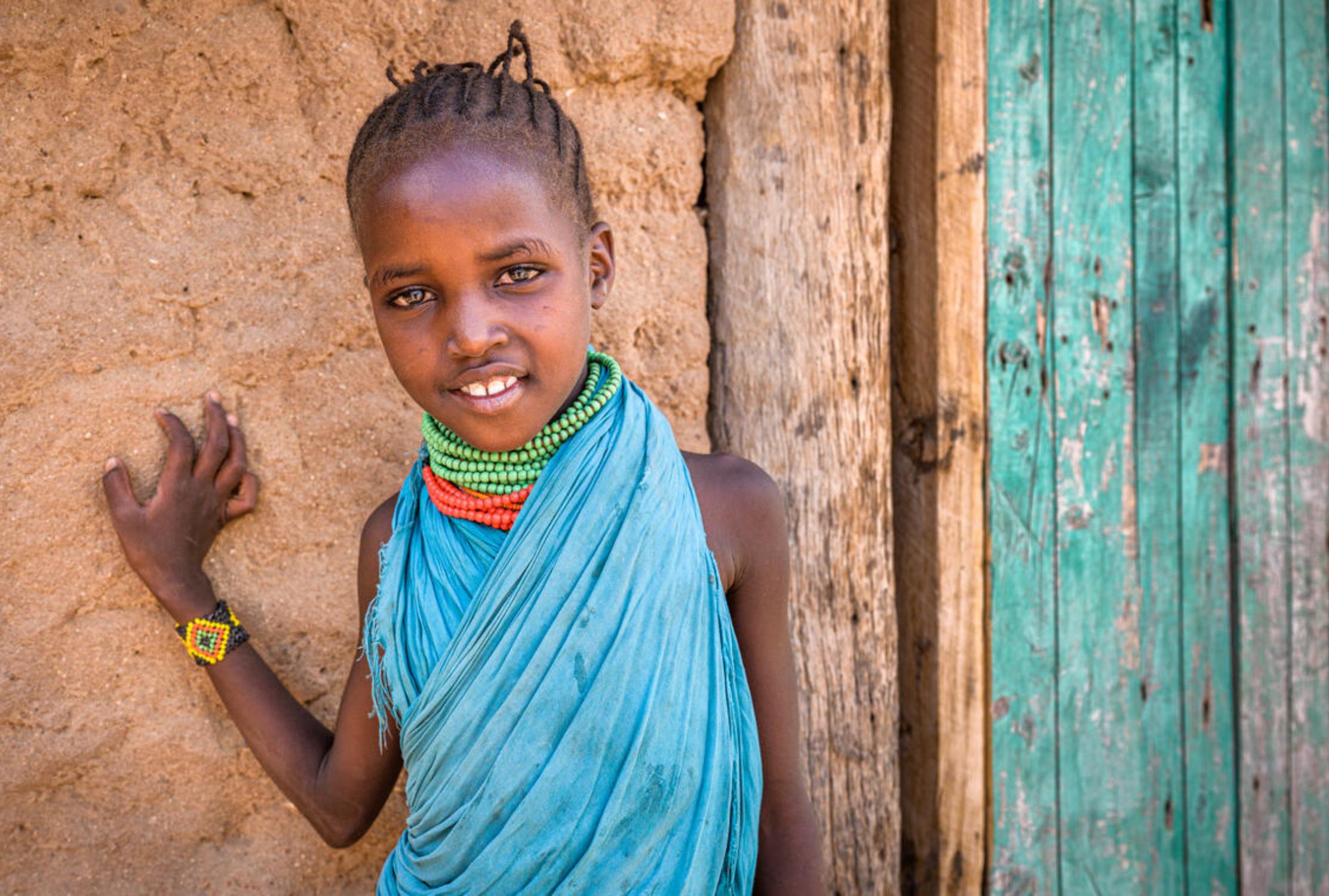 A sponsored girl from Kenya smiles outside her home