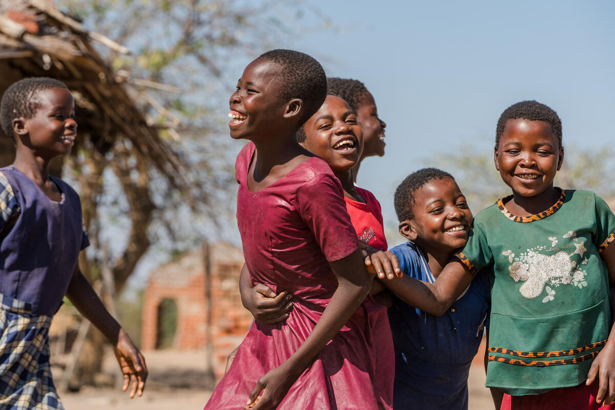 Community in Malawi, including sponsored children, smile and play in celebration 