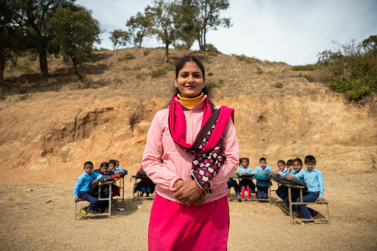 A former sponsored child from Nepal stands in front of the students she now teaches