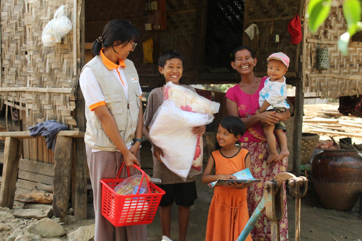 WV staff member smiling with family who recieved WV supplies