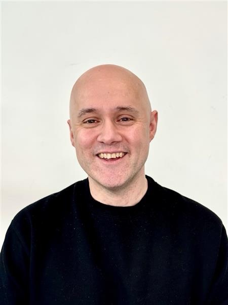 A headshot of Don Esson, he's smiling and has a black jumper on.