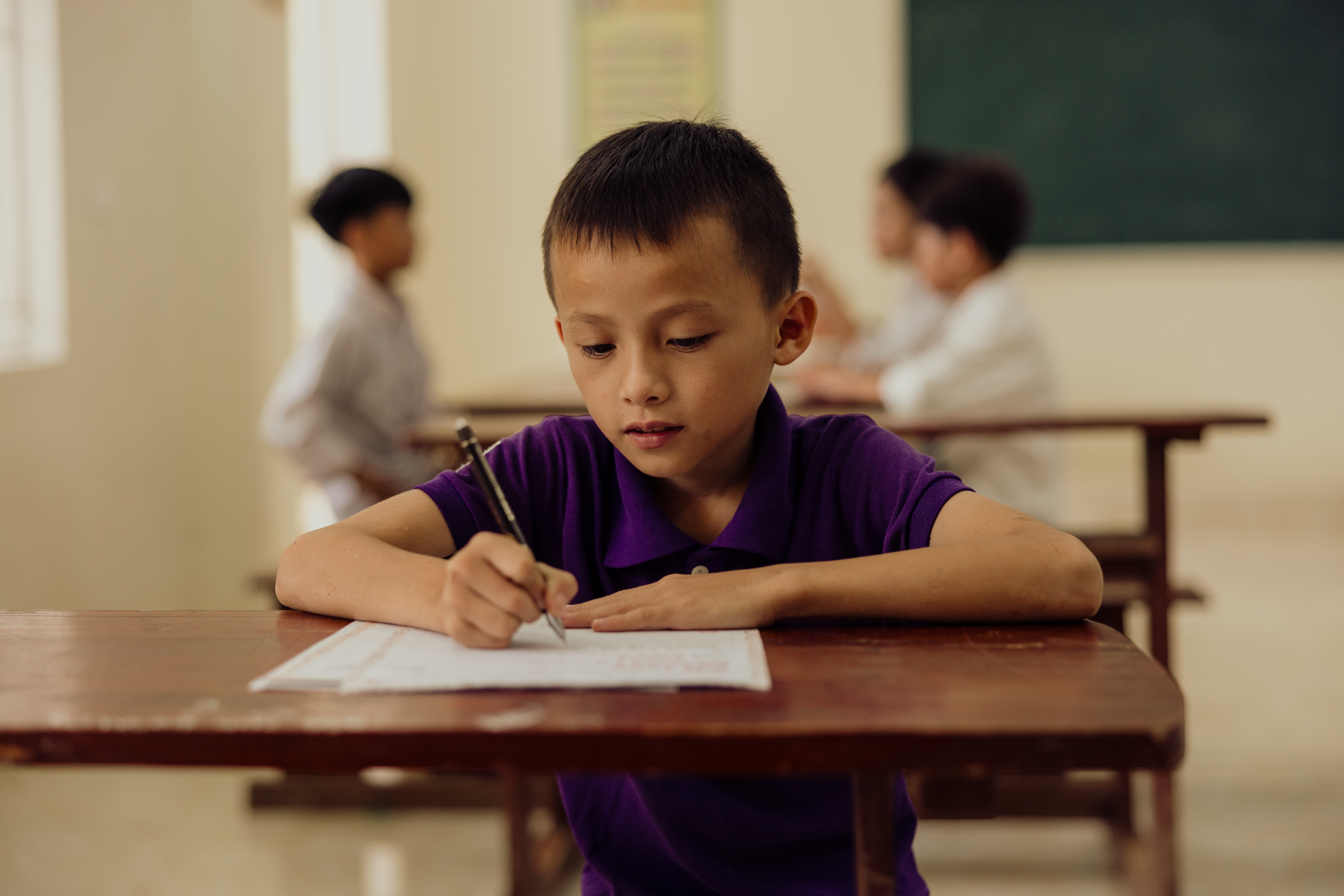 A young boy in Vietnam writing to his sponsor