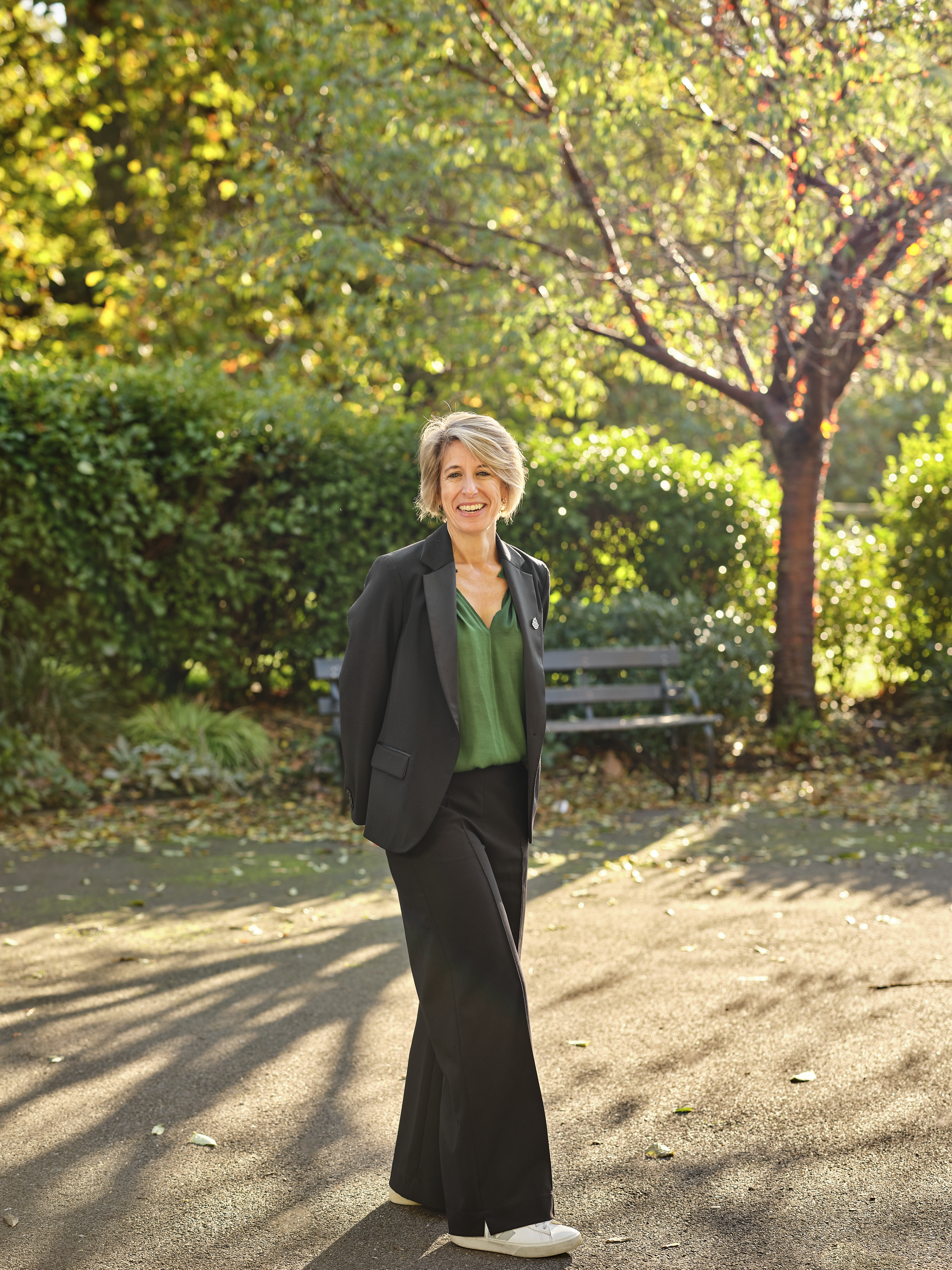 Sarah Bissell poses, there's a park bench behind her