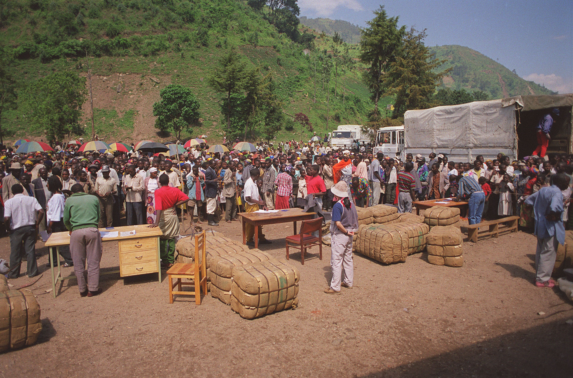 People in Rwanda stand on a hillside with the few possessions they could salvage