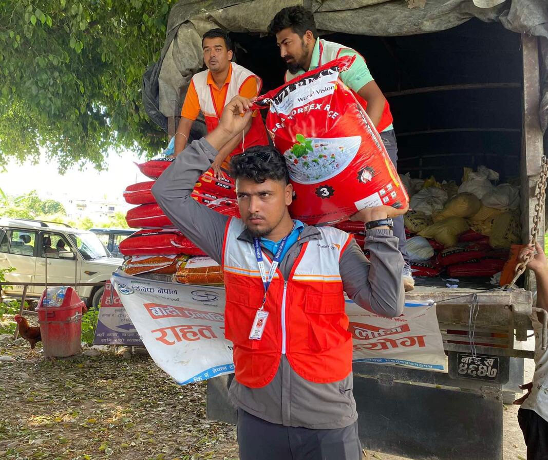 A World Vision staff member unloads emergency supplies from a van following floods in Nepal