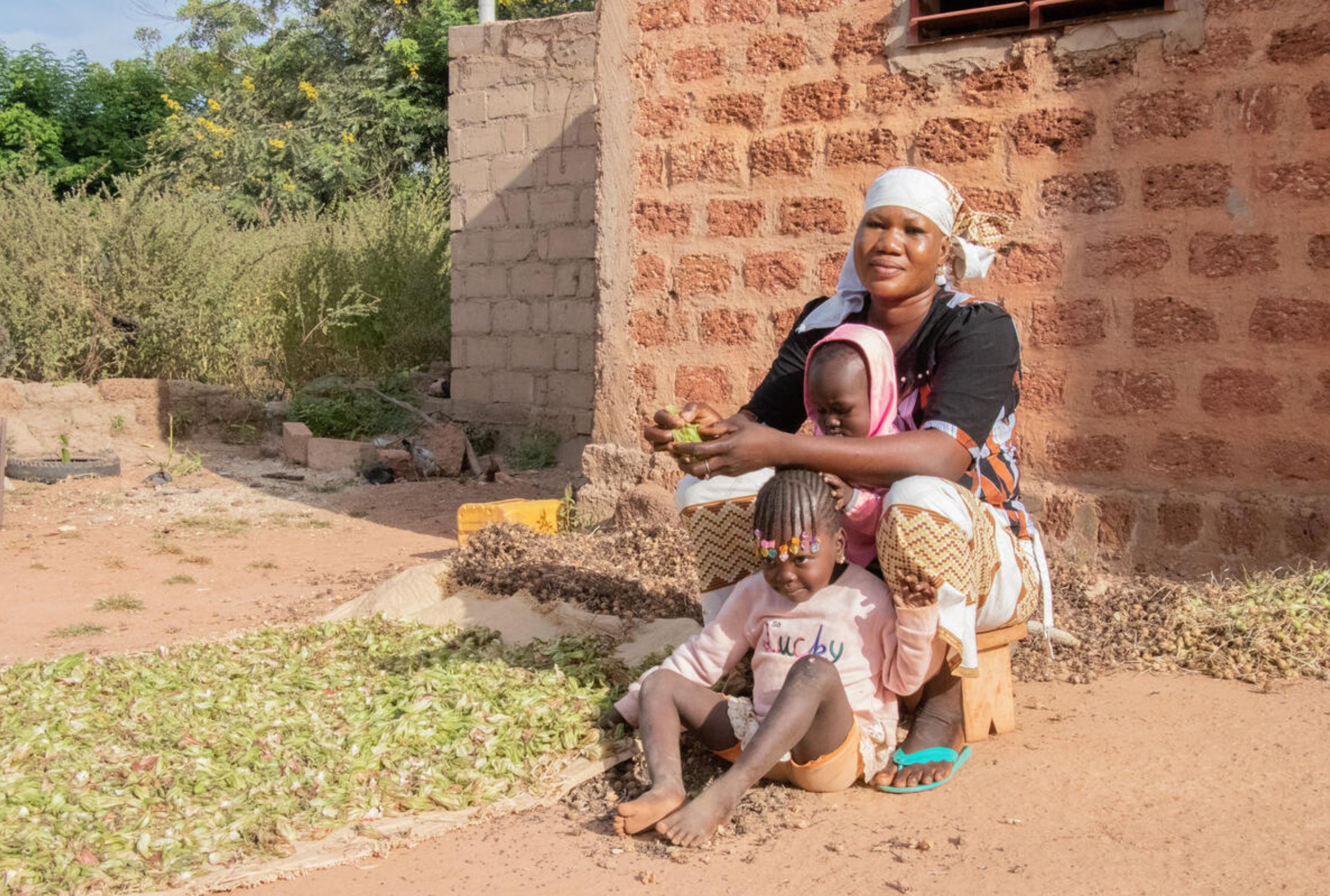 Mother from Burkina Faso making soap with her two young children