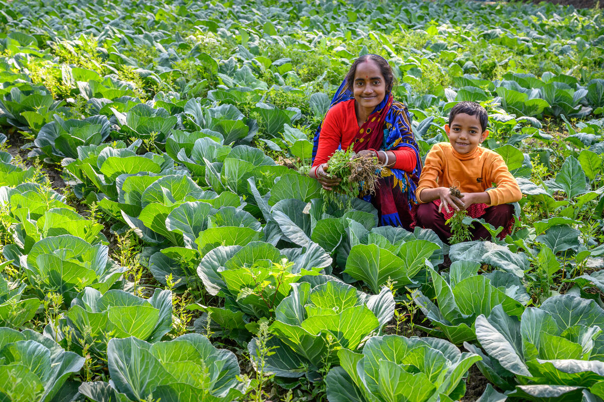 A mother and child sit amongst their harvest in Bangladesh
