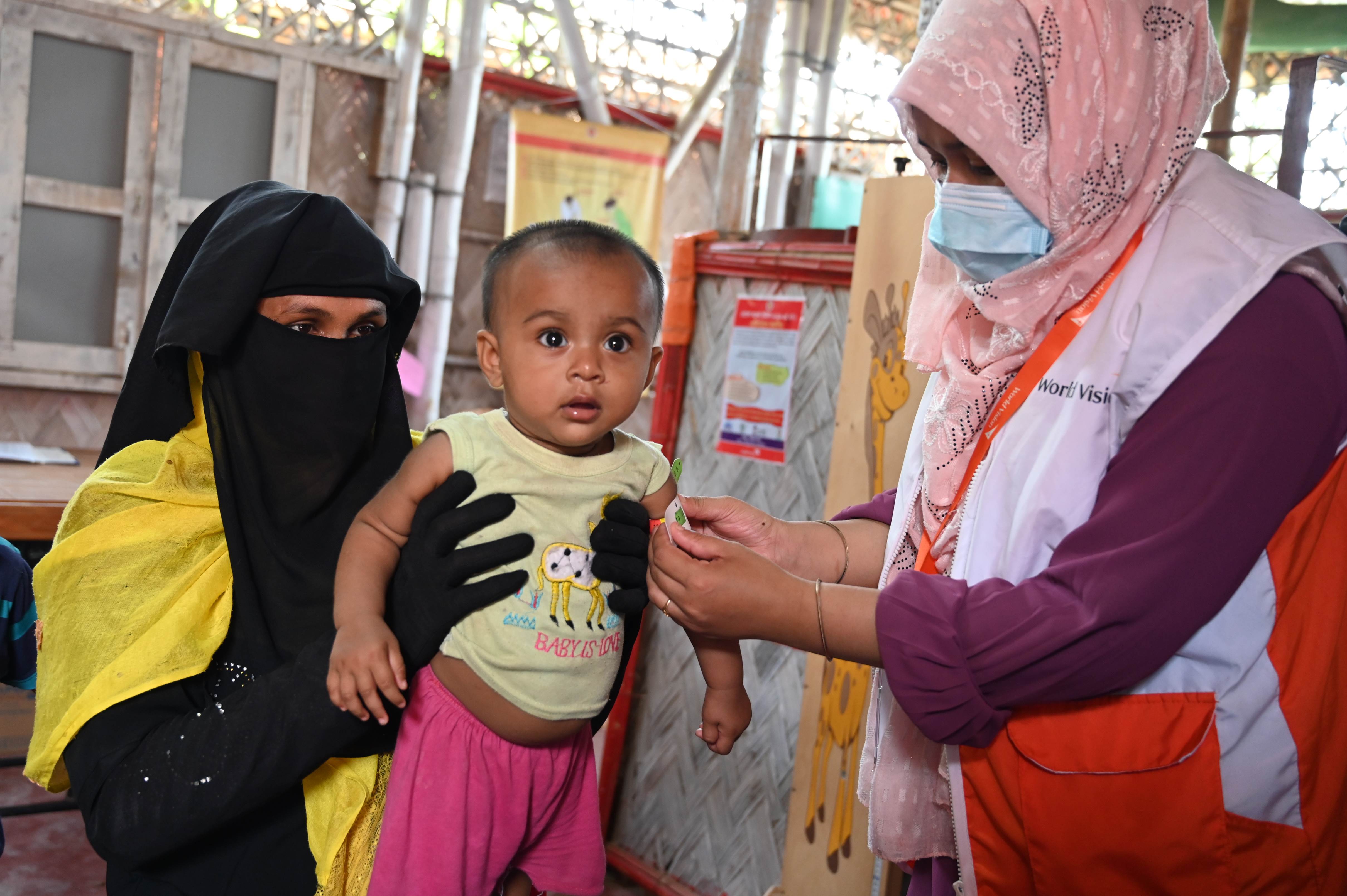 A young child having her arm circumference measured