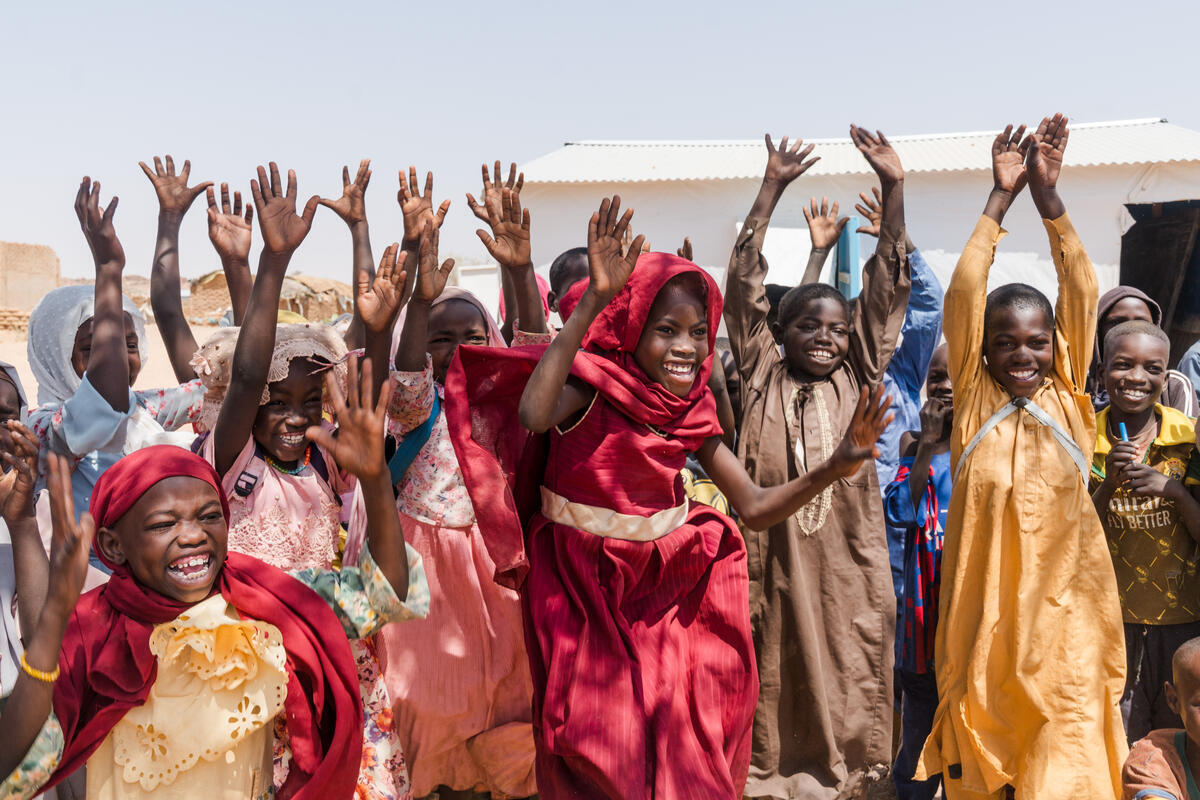 Young children excitedly raise their hands