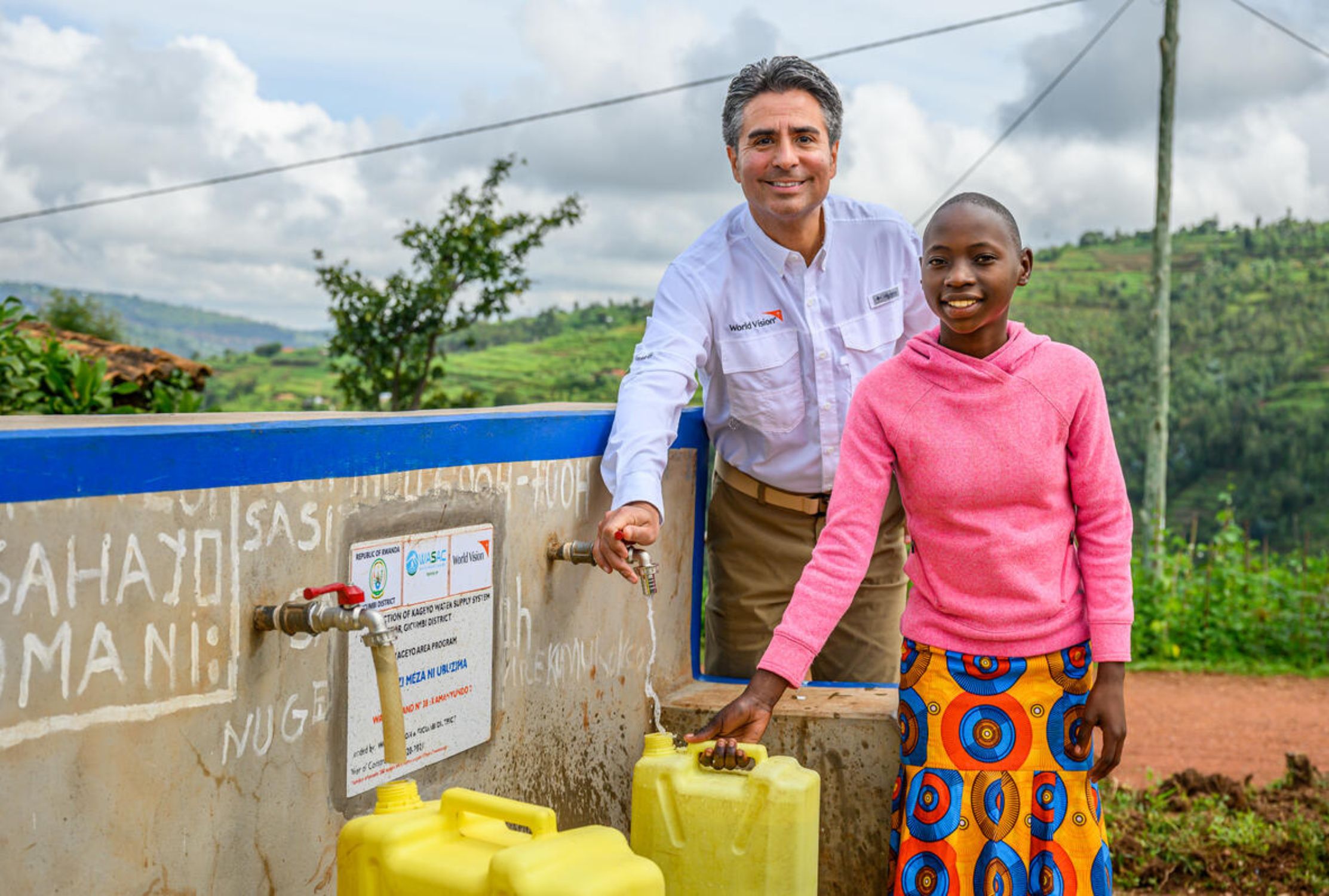 Girl from Rwanda collecting water next to President and CEO of World Vision US 